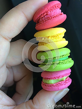 Colorful rows of macaron in hand Stock Photo